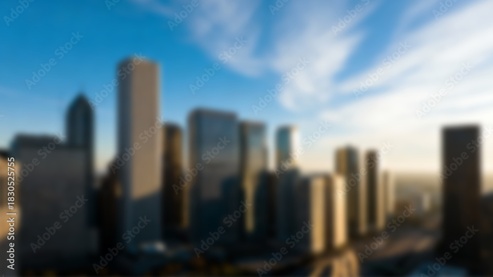 Fototapeta premium Blurred city skyline panorama with numerous skyscrapers under a luminous cloudy sky