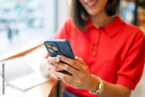 Woman connecting with smartphone, enjoying social media content in cafe