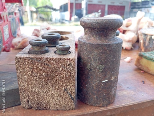 Quadro em tela Vintage rusty iron scale weights set on a wooden block, used for traditional market measuring and antique tool collection
