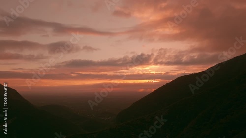 Aerial Dolly In Reveal of Sunrise Behind Silhouetted Sierra Madre Mountains