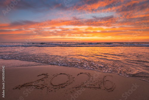 Fototapeta Naklejka Na Ścianę i Meble -  Happy New Year 2026 text on the beach sand beautiful sea sunrise