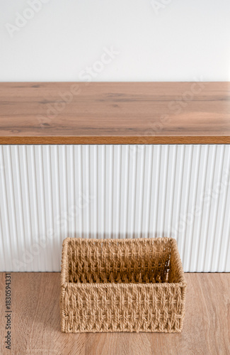 Woven Jute Basket on Wooden Floor with Modern Cabinet
