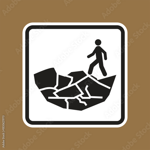 Caution sign depicting a person walking on broken ground or unstable terrain