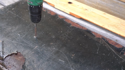 A Close-Up Look at the Tool in Action: Drilling into a Metal Surface with Visible Wear and Tear, Highlighting the Tool's Precision and Purposeful Design.. Video with sound