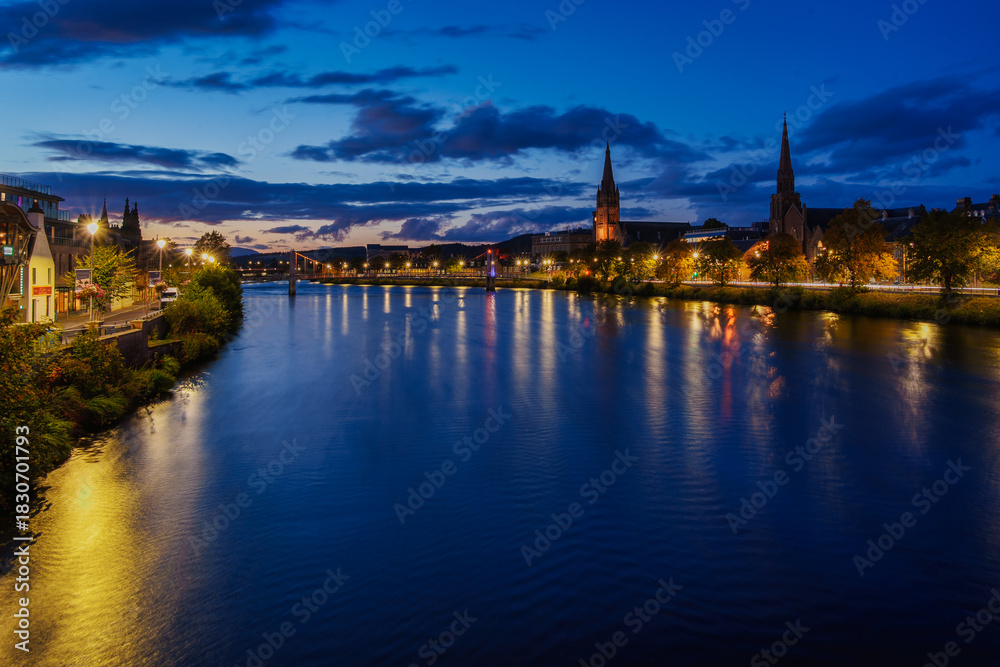 Fototapeta premium River ness flowing through inverness cityscape at blue hour