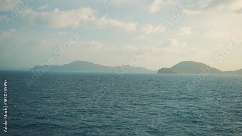 4K shot of sea in front of Phuket islands with clouds in the sky during the sunrise as seen from a boat in Phuket, Thailand. Scenic view of islands during the early morning. Scenic island Background.