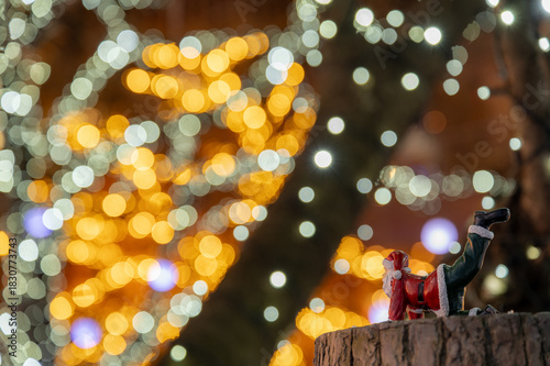 ポーズを決めるサンタとカラフルなイルミネーションの冬の風景