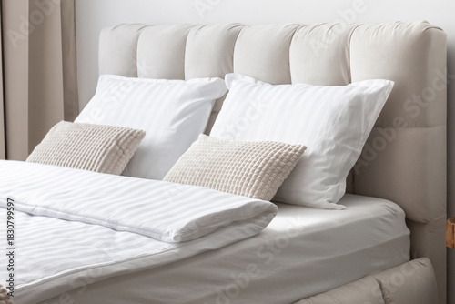 Comfortable soft white and gray pillows on the bed, guest accommodation ready