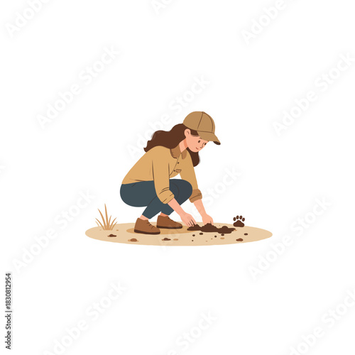 Young woman examining a paw print in the dirt with her hands outdoors in nature during the day