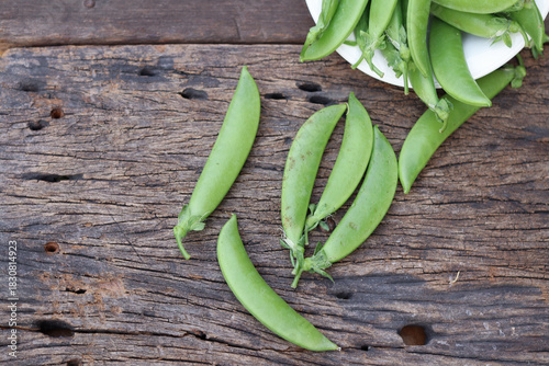 Fresh green peas in wooden bowl close-up