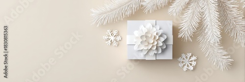 Elegant white gift box with floral bow and snowflakes on beige background