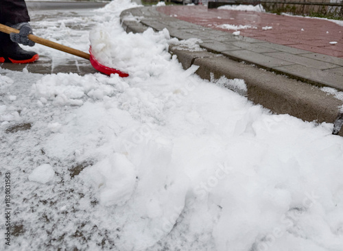 A child shovelling snow near pedestrian walk