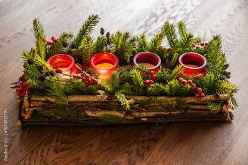 Advent wreath made of branches with two candles burning on Christmas Eve