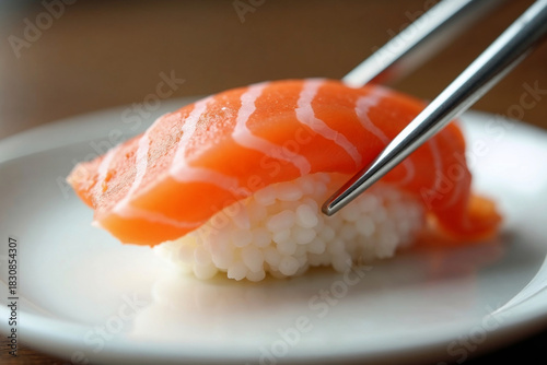 Fresh Salmon Nigiri Sushi Picked Up by Japanese Chopsticks