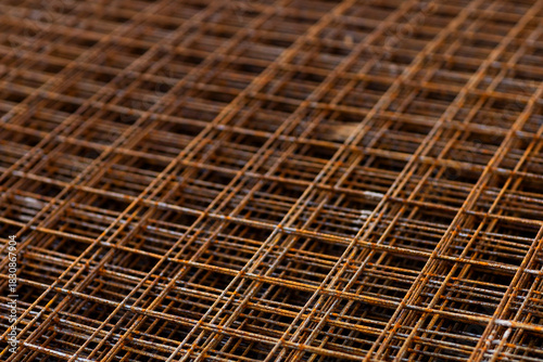 Close-up of a grid of rusty steel reinforcement mesh used in concrete construction, revealing texture, pattern, and oxidation color.