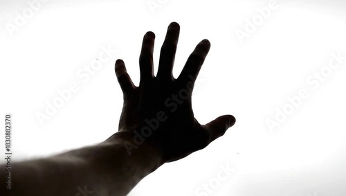 Silhouette of a clenched fist against a bright white background, symbolizing power and determination