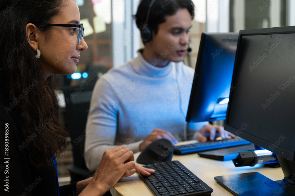 Fototapeta premium Customer support team in a modern call center receiving guidance from a supervisor. Diverse employees working with headsets and computers, representing teamwork, communication, and business 
