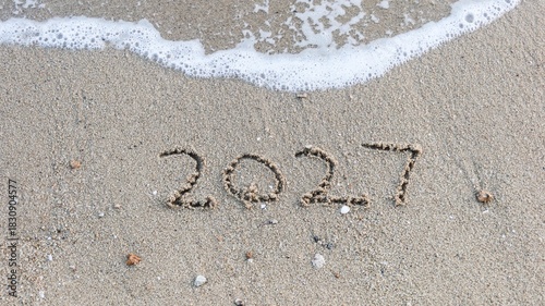 close up of year 2027 numbers written on the sand