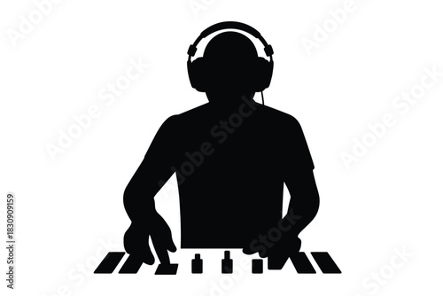 Silhouette of a dj with headphones playing music on a synthesizer