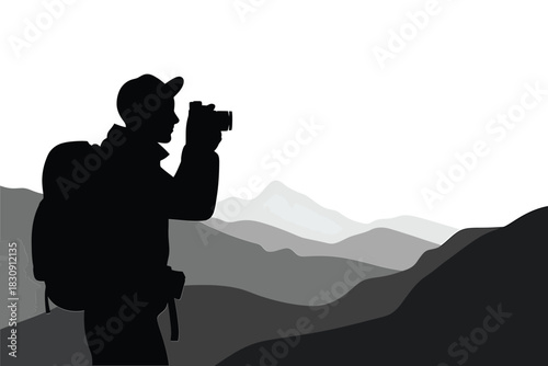 Silhouette of a photographer with backpack taking pictures in the mountains