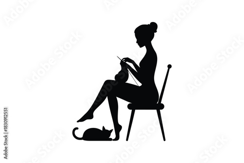 Silhouette of a woman knitting with a cat at her feet