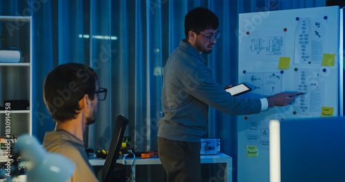 Team adult male engineer develop present AI robotics hand project at tech workspace night. Artificial intelligence, collaboration support prototype development, robotic, machine learn, training.