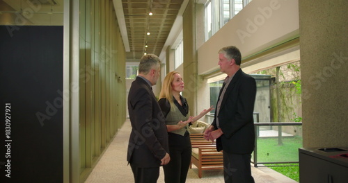 Wallpaper Mural Group of business colleagues talking in modern office hallway, professional team engaging in relaxed workplace conversation during informal meeting Torontodigital.ca