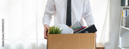 lay off workers. Banner size closes up hands of usinessman holding box of stuff to leave office after fired from work.