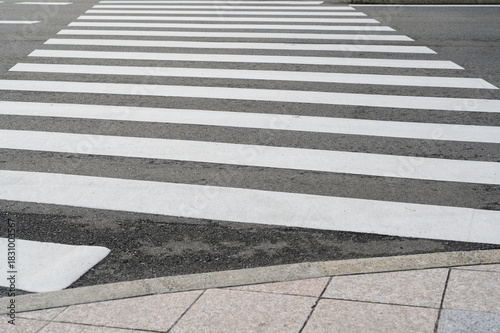 Empty pedestrian crosswalk on urban street, symbol of safety, transportation, and modern city infrastructure.
