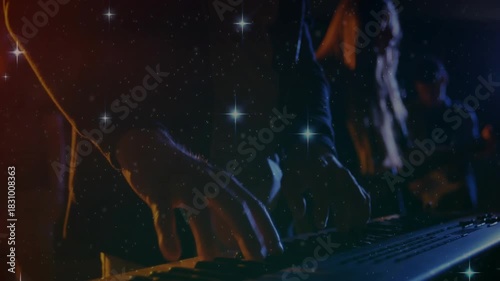 Keyboardist playing keys on singer cue, camera closing while star sparkling over band driving music