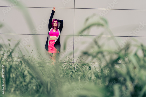 Woman with pink hair posing in urban fashion