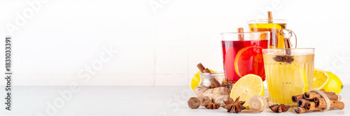 Three different Hot Toddy drinks in different tea cups - hot autumn winter tea cocktail beverages with scotch, rum and mezcal alcohol drinks, spices, lemon and honey