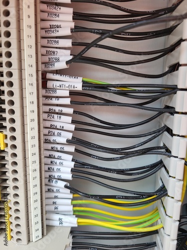 Close-up view of organized electrical wiring in a control panel, showcasing various labeled cables and connectors, emphasizing the importance of neatness in electrical installations