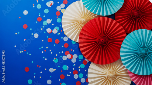 Festive paper fans and confetti on a vibrant blue background