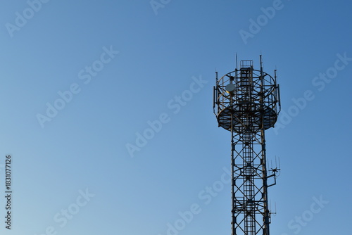 Looking up at a mobile phone tower on a sunny day.	