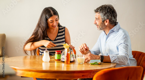 Smiling couple preparing toast together during cozy breakfast time