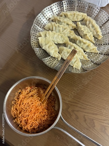 Korean Spicy Bibim Noodles with Steamed Dumplings on Table
