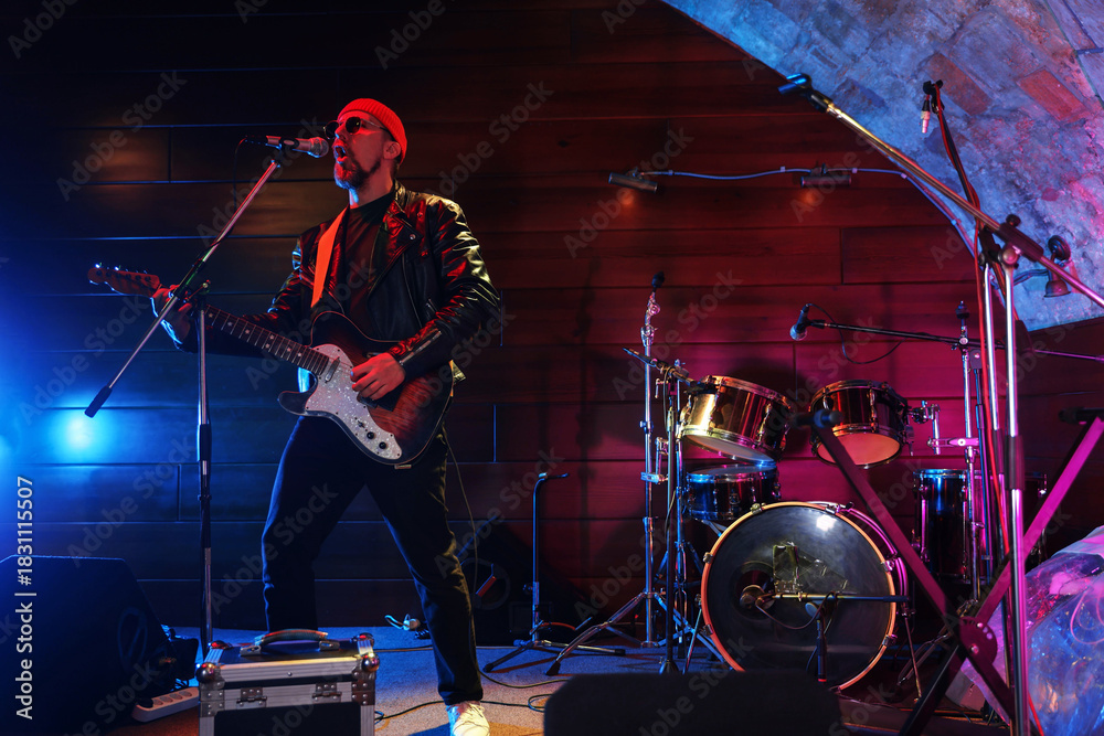 Fototapeta premium Handsome man playing electric guitar on stage