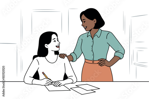 Two women communicate while one is working at a desk