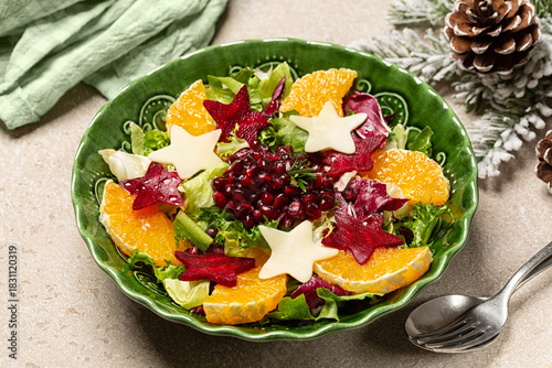 Beautiful festive Christmas and New Year winter salad with star shaped beetroot, oranges, pomegranat and cheese. Healthy food concept.