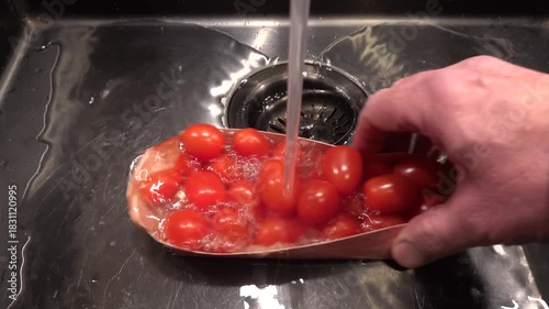 Stockholm, Sweden A cook rinses cherry tomatoes under running water in a sink. 