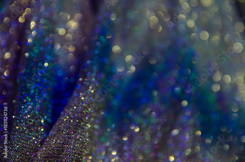 Multicolor shiny background. Fabric screensaver. Festive decoration. Light and bokeh.