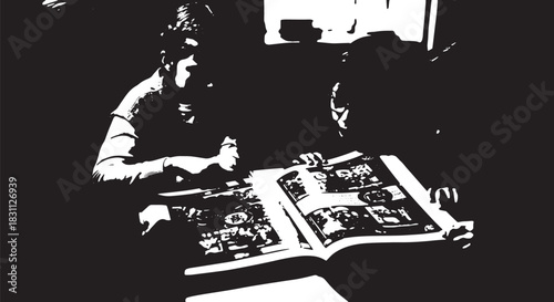 Two adults examine a large open magazine at a table in a high-contrast black and white indoor scene.