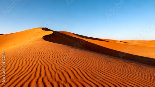 Fototapeta Naklejka Na Ścianę i Meble -  Golden sand dunes under a clear blue sky in the desert landscape