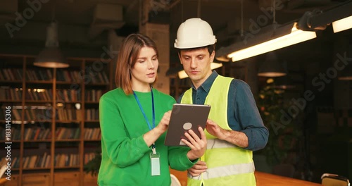 Architect and construction foreman discussing project on digital tablet
