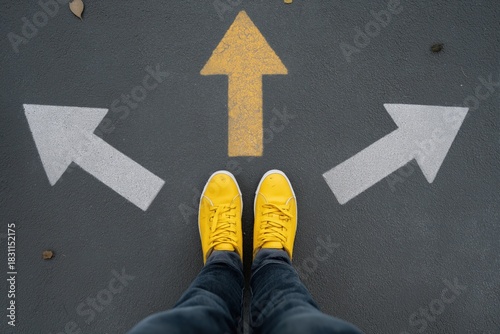 Person deciding path with arrow choices on asphalt in yellow shoes