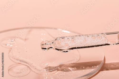 Gel textured facial serum with pipette on a pink background