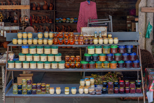 Colorful jars of honey and jams at rustic roadside stall