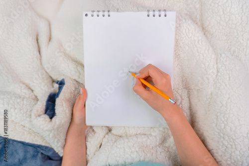 Person drawing with pencil in a book