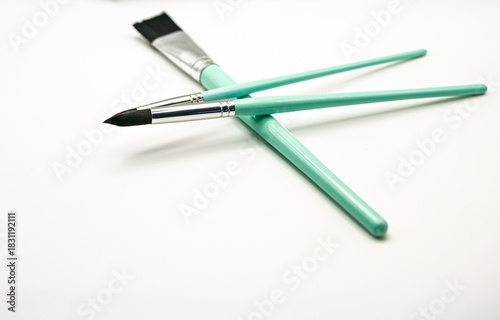 A group of three teal paintbrushes